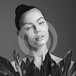 Portrait of a beautiful woman with grass leaves in her hands