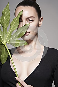 Portrait of a beautiful woman with grass leaves in her hands