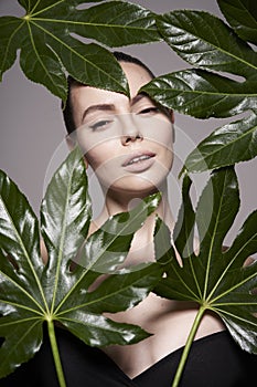 Portrait of a beautiful woman with grass leaves in her hands