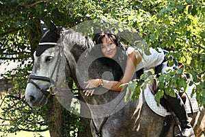 Portrait of beautiful woman and gray horse in garden