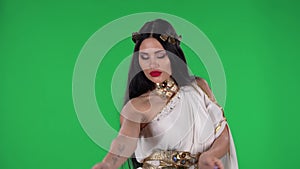 Portrait of beautiful woman in greek greece goddes dress and wreath high fashion is looking straight and dancing. Green