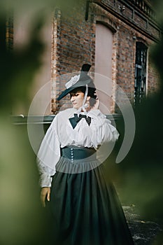 Portrait of beautiful woman in green vintage hat 1800s early 1900s clothing. photo