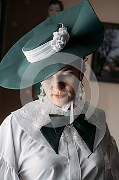 Portrait of beautiful woman in green vintage hat veil 1800s early 1900s clothing.