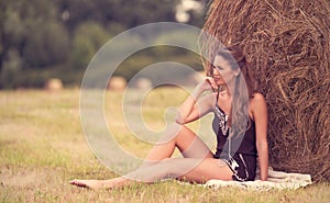 Portrait of a beautiful woman with hay bale