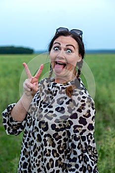 Portrait of a beautiful woman in her fifties outdoors making funny faces