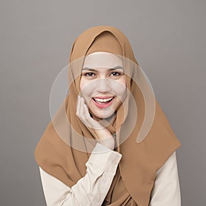 Portrait of beautiful woman with hijab is smiling on gray background photo