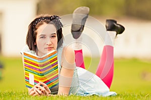 Portrait of beautiful woman holding a book and standing outside