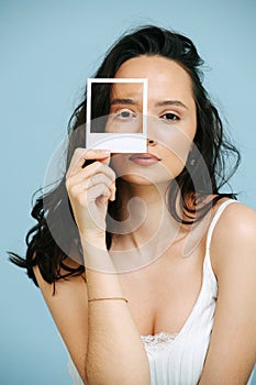 Portrait of beautiful woman holding frame over eye with vitiligo eyelashes