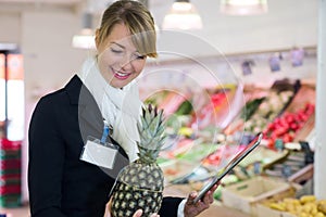 portrait beautiful woman holding pineapple in supermarket