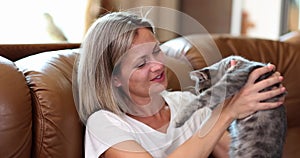 Portrait of beautiful woman holding small cat from happiness at home