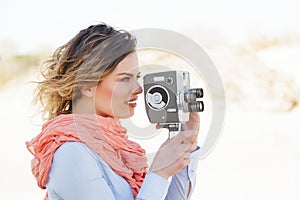 Portrait of beautiful woman holding vintage 8mm camera