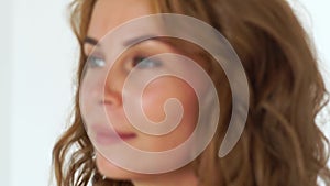 Portrait beautiful woman with long brown hair in white studio. Close up face freckles woman with curly hairstyle.