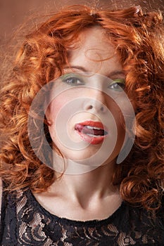 Portrait of beautiful woman with long curly red. Display language.