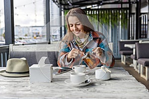 Portrait of a beautiful woman with long hair sitting at a table in a cafe.