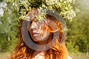 Portrait of beautiful woman with long healthy hair outdoor. Summer portrait. Woman in flower wreath