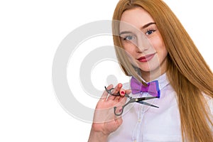 Portrait of a beautiful woman with luxurious hair on a white background. She has scissors in her hands. Her profession is a