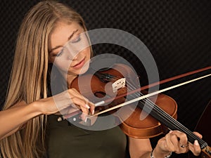 Portrait of beautiful woman musician plays the violin