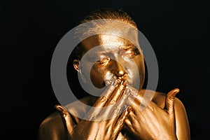 Portrait of beautiful woman painted in gold