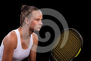 Portrait of beautiful woman playing tennis indoor. Isolated on black.