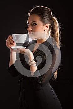 Portrait of beautiful woman posing in studio with cup of coffe