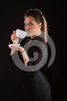 Portrait of beautiful woman posing in studio with cup of coffe