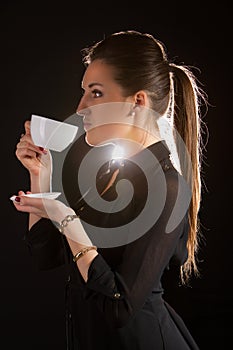 Portrait of beautiful woman posing in studio with cup of coffe