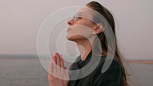 Portrait of beautiful woman praying in nature.