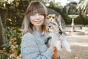 Portrait of a beautiful woman with rare little size purebreed dog - Biewer Terrier. Girl is walking in the park with her cute