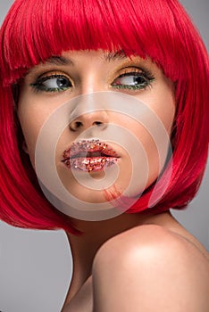portrait of beautiful woman with red hair and glitter on face looking away