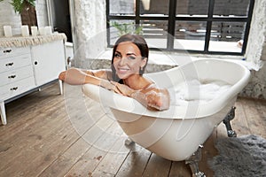 Portrait beautiful woman relaxing lying in the bathtube in the bathroom photo