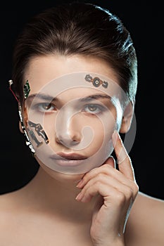 Portrait of a beautiful woman`s face with half human face and half face robot.