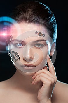 Portrait of a beautiful woman`s face with half human face and half face robot.