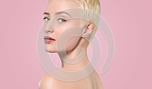 Portrait of a beautiful woman with short blonde hair, beautiful fresh make-up and with healthy clean skin on a pink background.