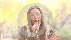 Portrait of beautiful woman singing with microphone