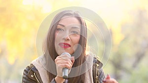 Portrait of beautiful woman singing with microphone