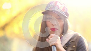 Portrait of beautiful woman singing into microphone and dancing