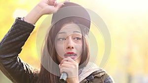 Portrait of beautiful woman singing into microphone and dancing