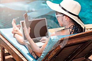 Portrait Beautiful Woman Sitting in deck chair and using laptop