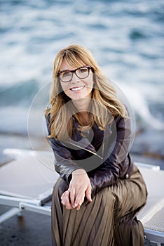 Portrait of beautiful woman sitting at the ocean and relaxing