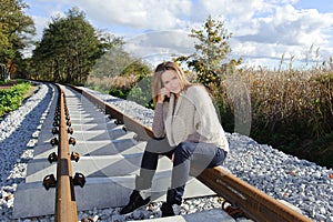 Portrait of beautiful woman smiling and sitting at railways