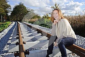 Portrait of beautiful woman smiling and sitting at railways