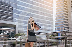 Portrait of beautiful woman smling and holding shopping bags in city