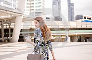 Portrait of beautiful woman smling and holding shopping bags in city