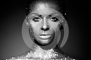 Portrait of beautiful woman with sparkles on her face