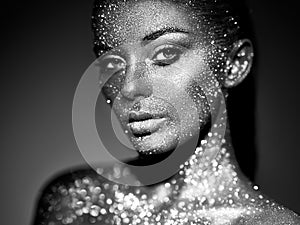 Portrait of beautiful woman with sparkles on her face