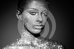 Portrait of beautiful woman with sparkles on her face