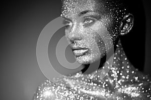 Portrait of beautiful woman with sparkles on her face