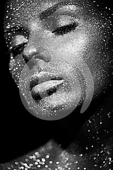 Portrait of beautiful woman with sparkles on her face