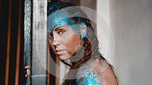 Portrait of beautiful woman with sparkles on her face. Girl with art make up