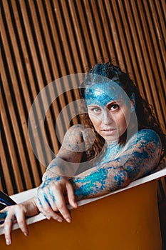 Portrait of beautiful woman with sparkles on her face. Girl in the bath